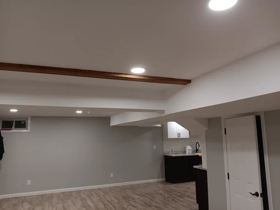 Basement with exposed beam and wet bar